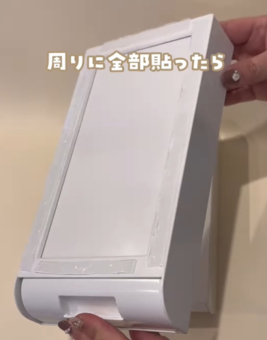『取り付け式引き出し』の底面に両面テープを貼る様子