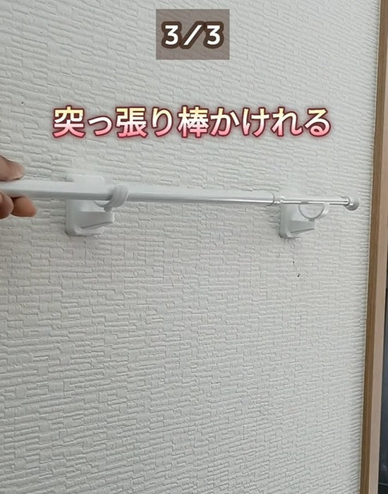 ２つ取り付けた回転ホルダーに突っ張り棒をかける様子
