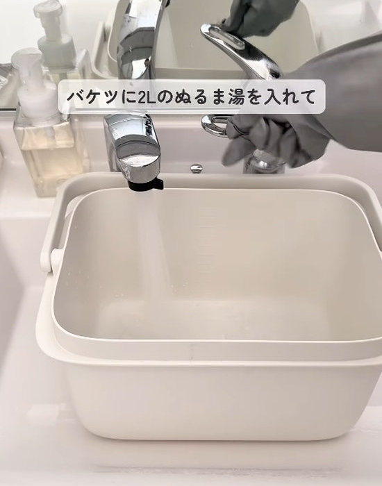 バケツにぬるま湯をためている様子