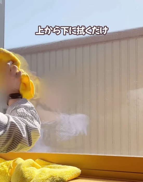 マイクロファイバーで窓を拭いている様子