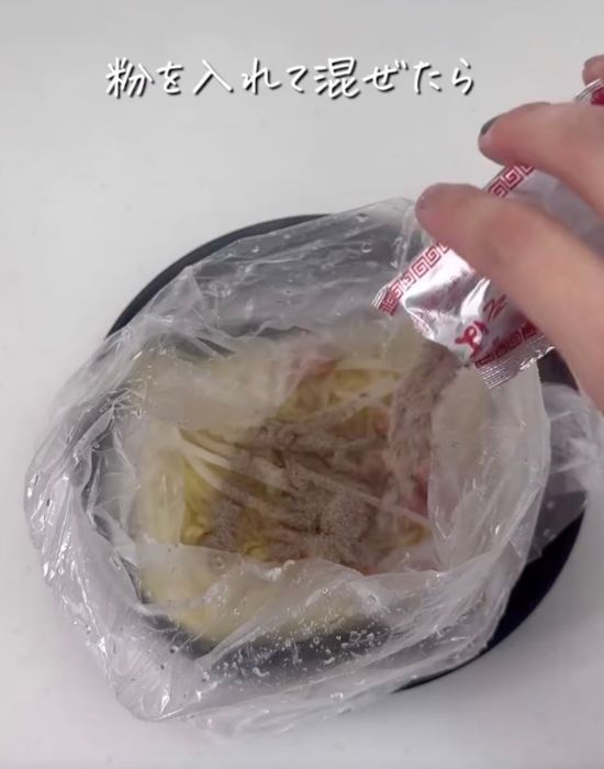 焼きそばの麺と具材を入れて加熱した『アイラップ』に焼きそばのソース粉を入れる様子