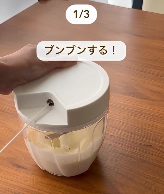 みじん切り器に生クリームを入れてひもを引っ張る様子