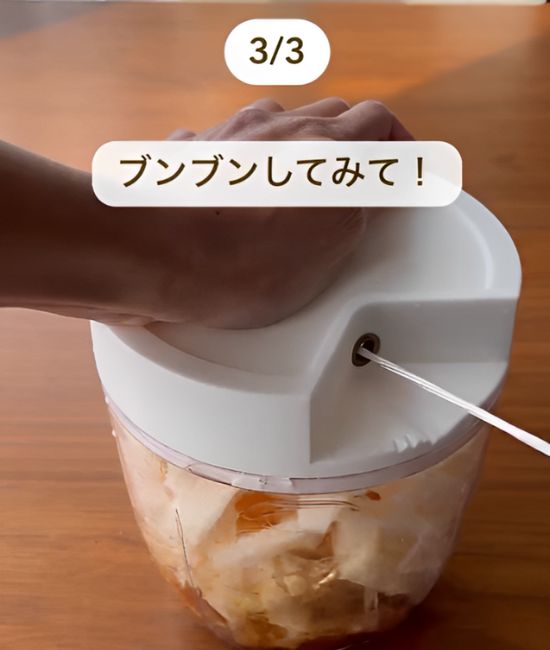 皮をむいてカットした山芋と卵黄と麺つゆと醤油を入れたみじん切り器のひもを引く様子