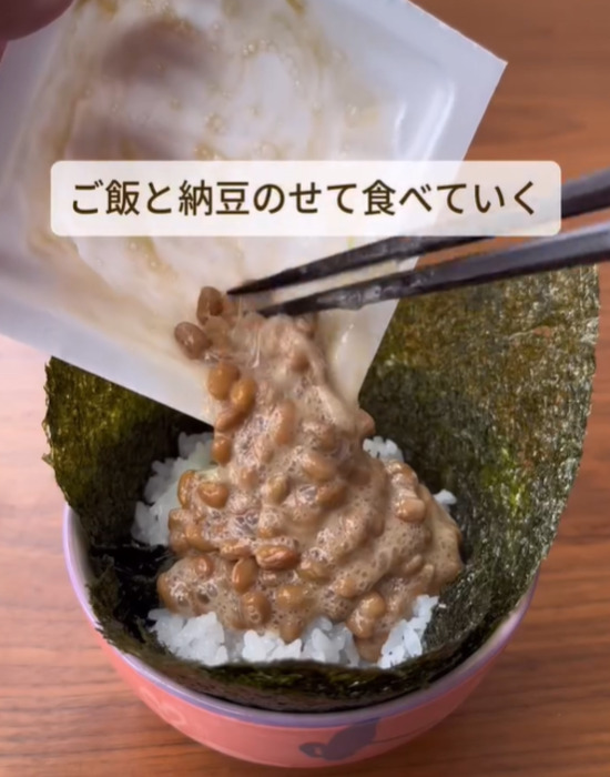 お椀のような形にしたのりの上にご飯と納豆をのせる様子