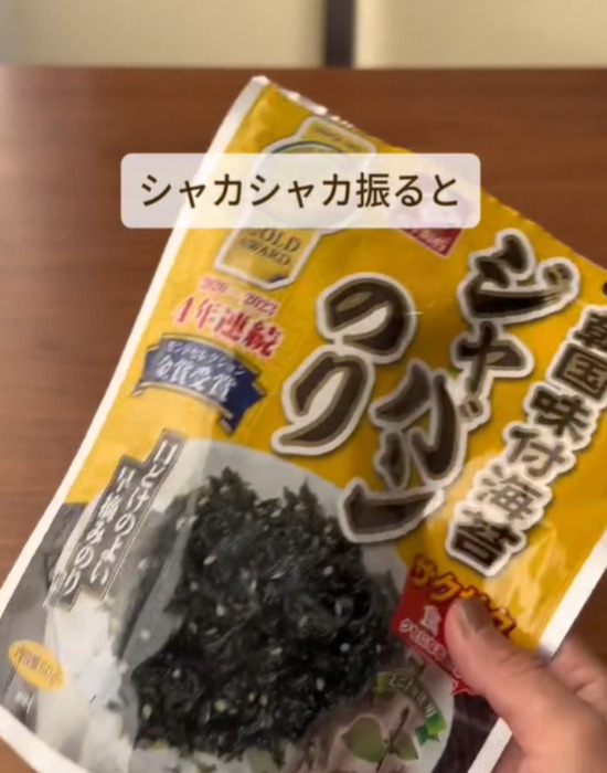 ご飯を入れたふりかけのりの袋を振る様子