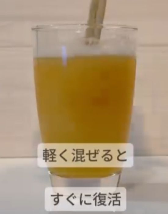 ビールの入ったグラスに割り箸を入れて混ぜる様子