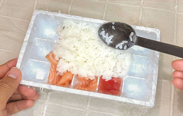 酢飯を敷き詰めている写真