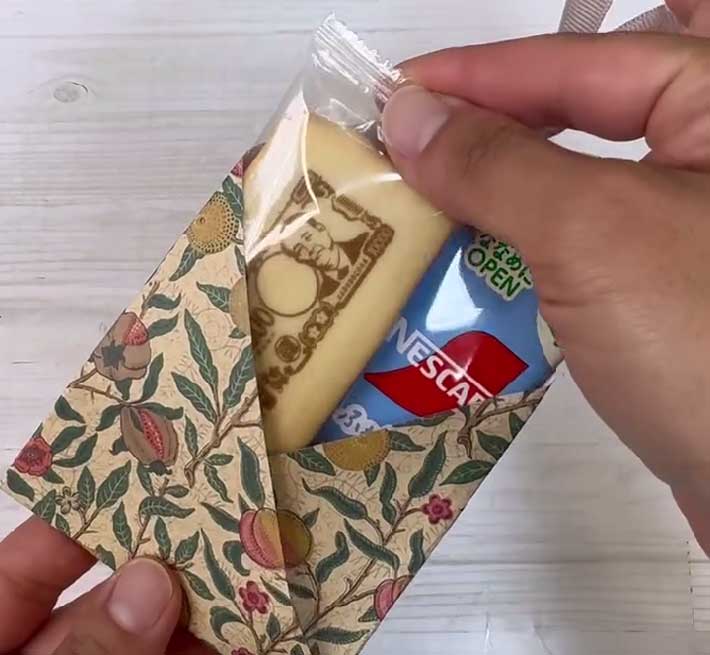 完成したラッピング容器に、お菓子の個包装やコーヒースティックを入れる