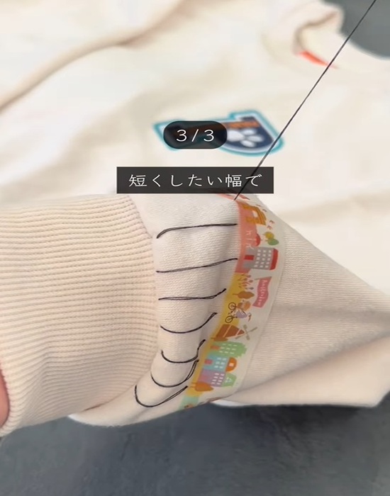 トレーナーの袖に針を通す様子