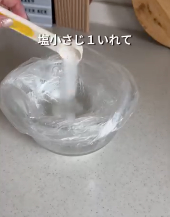 容器にビニール袋をかぶせて水と塩を加えている画像