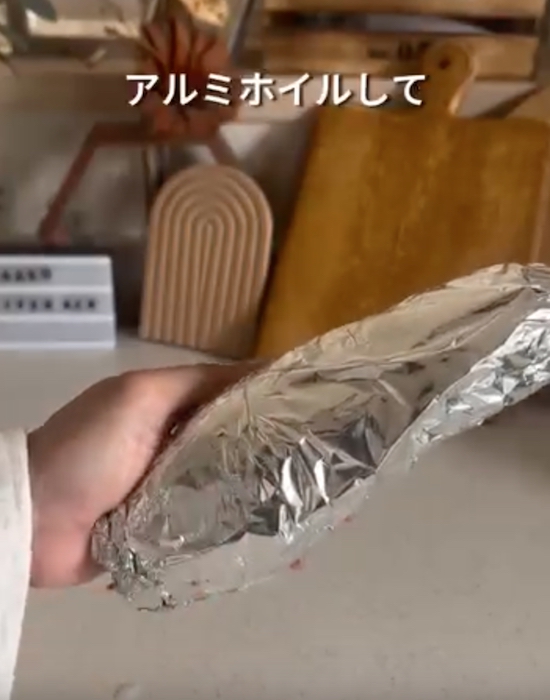 サツマイモをアルミホイルで包んでいる画像