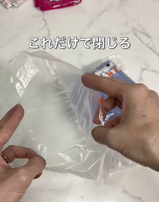 閉じているビニール袋を持っている人の手元