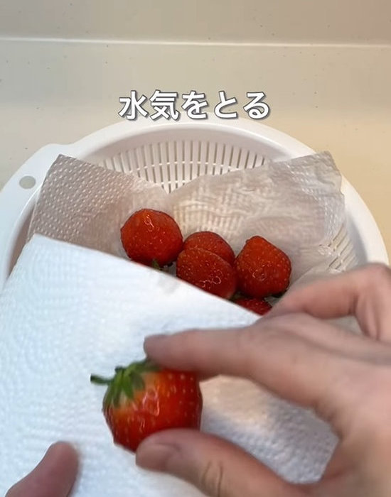 キッチンペーパーでイチゴの水気を拭う様子