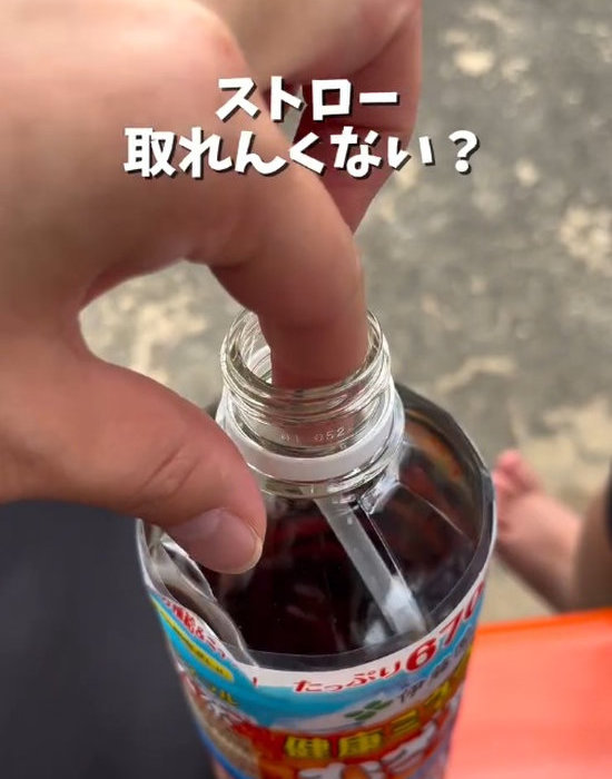 ペットボトルに入ったストローを取り出そうとしている様子