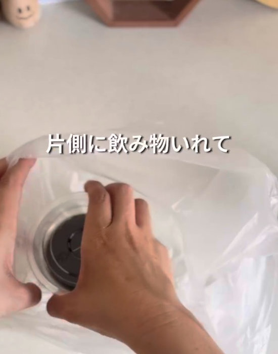 袋に飲み物の入ったカップを１つ入れる様子