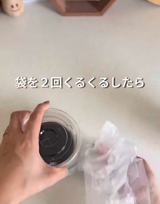 カップの入っていない部分の袋をねじる様子