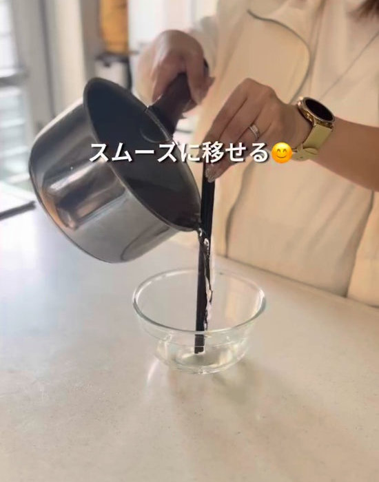 菜箸を使って鍋からボウルに水を注いでいる様子