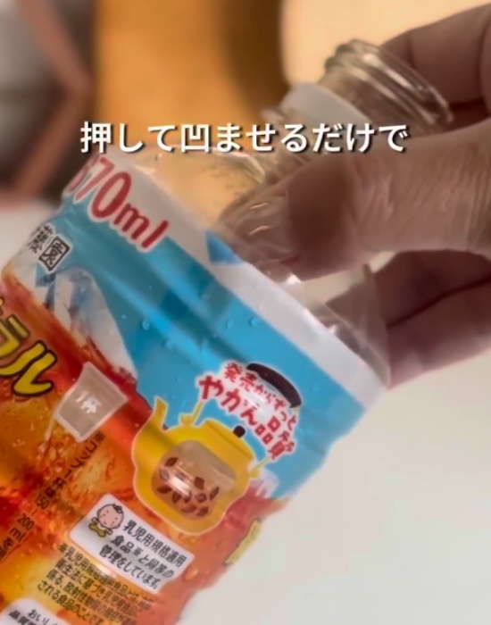 ペットボトルのミシン目上を押している様子