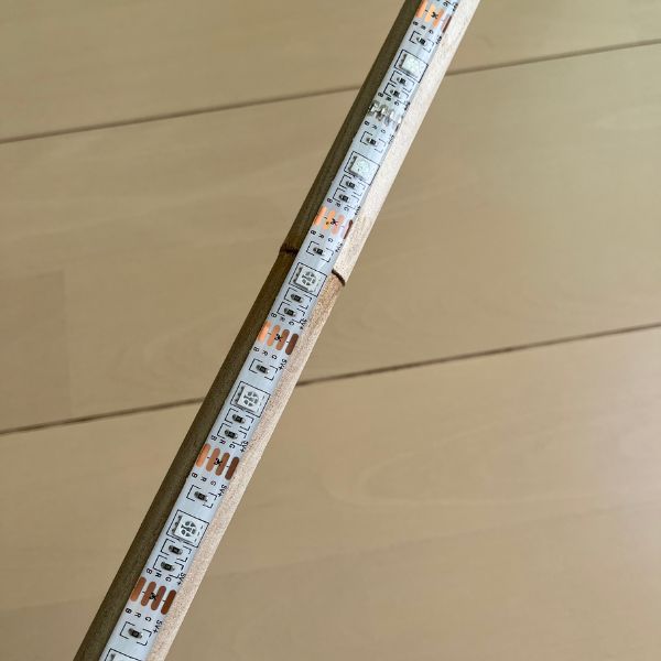 テープライトを丸棒に貼り付ける様子