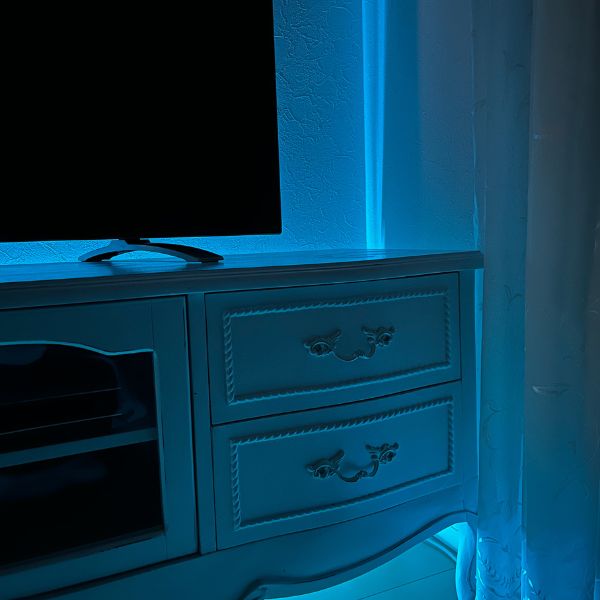 テレビボードの裏側に設置したテープライトで部屋全体が青っぽい光に包まれている様子
