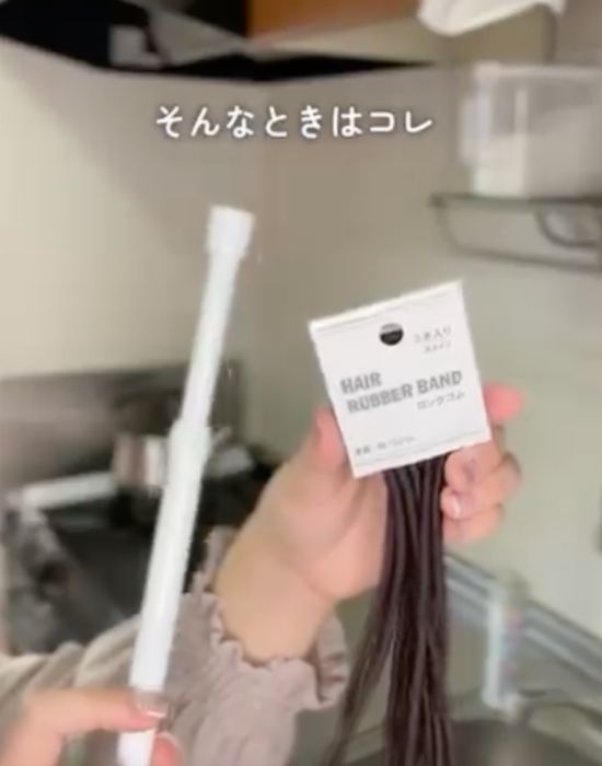 突っ張り棒とヘアゴムを持っている様子