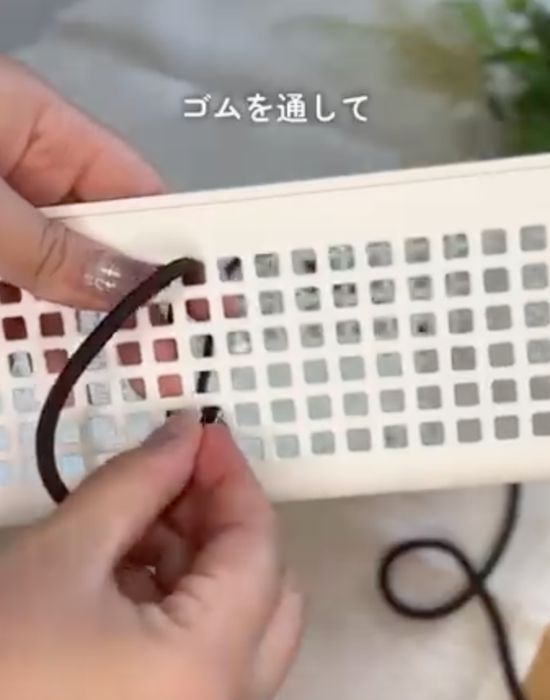 上から通したヘアゴムをメッシュかごの『下から２番目の穴』に通す様子