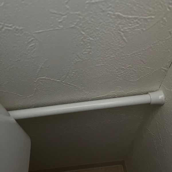 壁とつっぱり棒の間に少し隙間を空けた様子