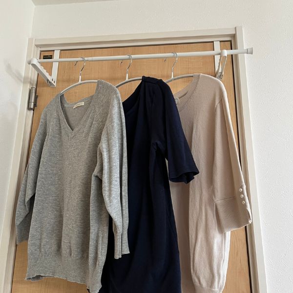 ドアの上部にフックをかけて作った簡易的な物干しざおに洗濯物をかけた様子