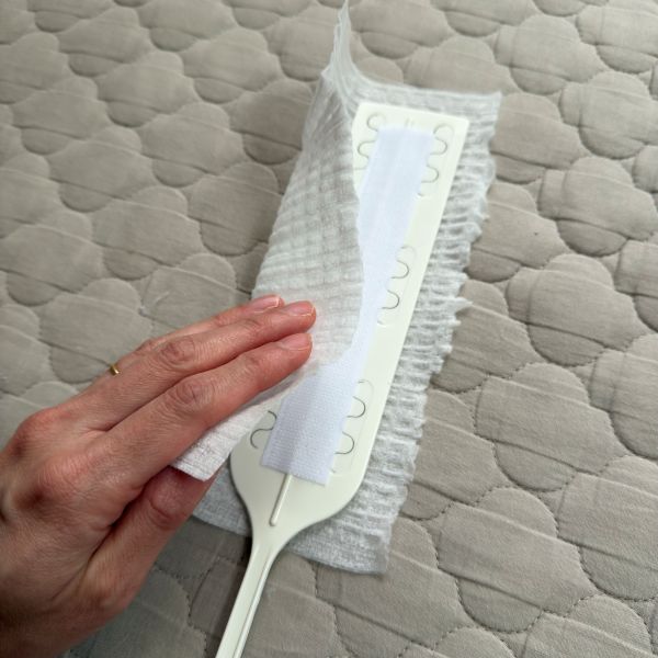 広げた掃除用シートの上に面ファスナーを貼り付けたハンディワイパーをのせた様子