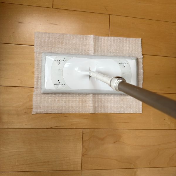 掃除用シートの上にフローリングワイパーを押し当てる様子