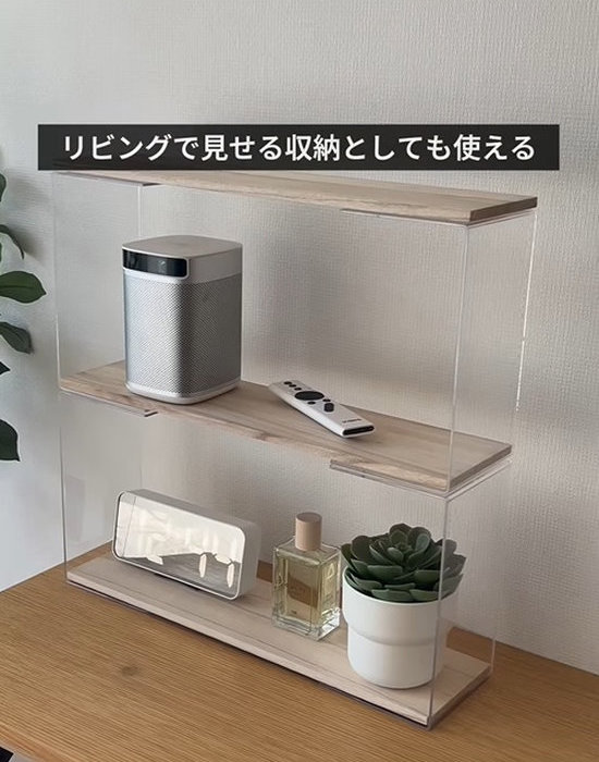 ディスプレイスタンドと木板を組み合わせた収納棚に時計やリモコンを置いている様子