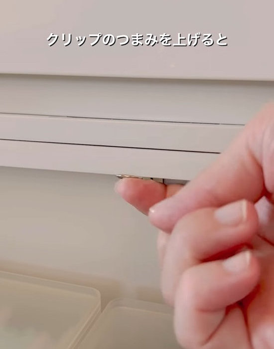収納ケースに付けたクリップのつまみを上げる様子