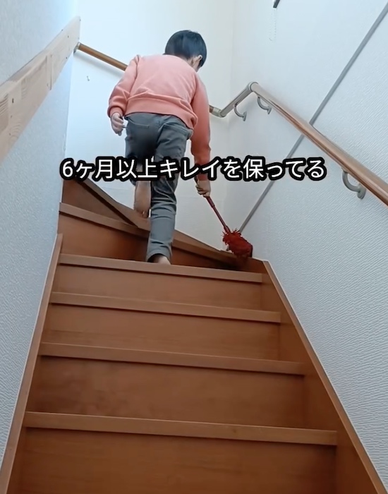 モップで階段掃除をする子供