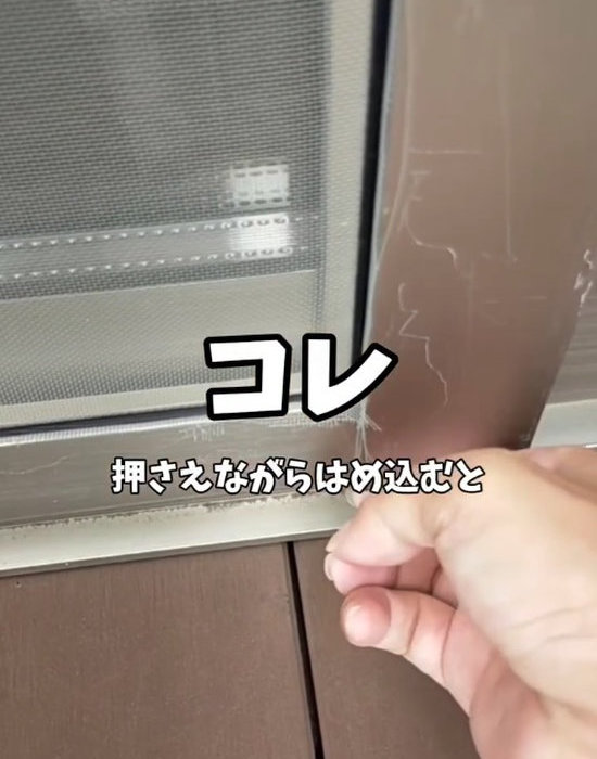 窓枠に網戸をはめ込んでいる様子