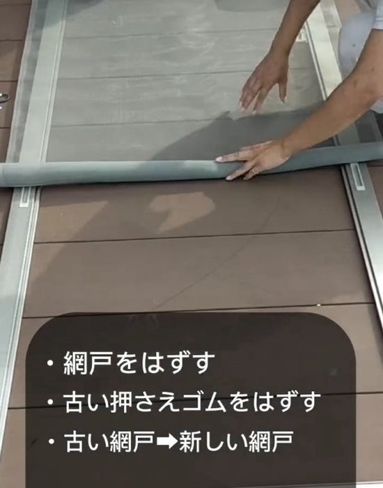 新しい防虫網を窓枠に広げている様子