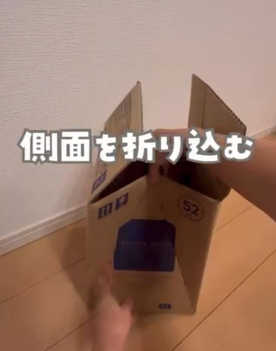 段ボールの側面を内側に折り込んでいる様子