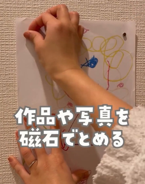 壁に置いた絵の上から磁石を当てる様子