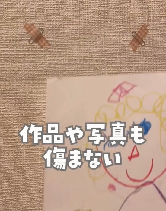 壁にマスキングテープで貼ったクリップと子供の描いた絵