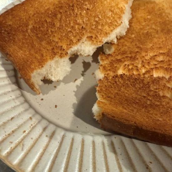 こんがり焼けた食パンを皿の上で割いた様子