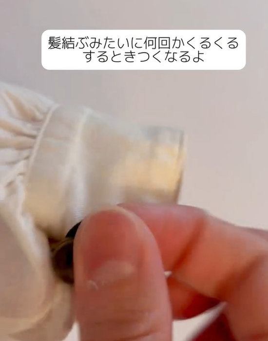 ボタンに通したヘアゴムをくくる様子