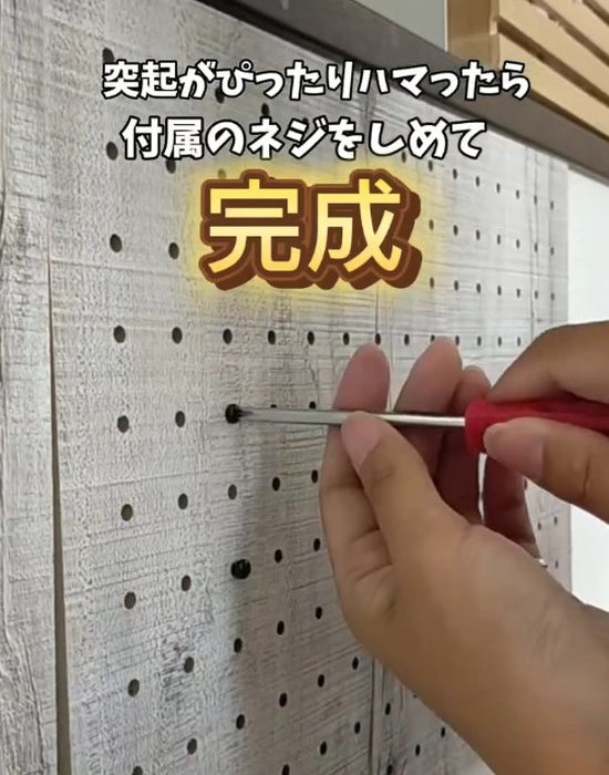 ネジを締めて有孔ボードを取り付ける様子