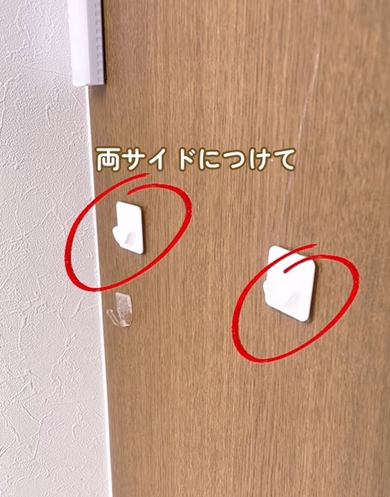 壁につっぱり棒壁面ガードを貼り付ける様子
