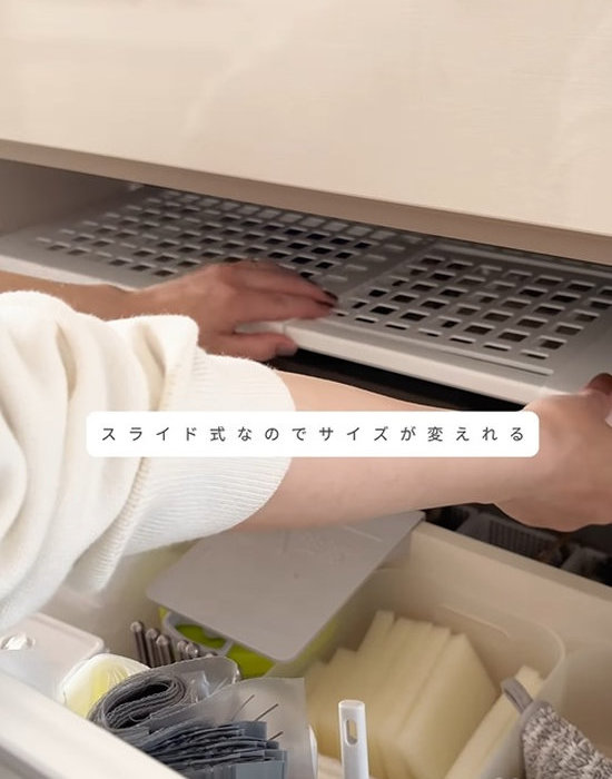棚をキッチンのシンク下に取り付けている様子