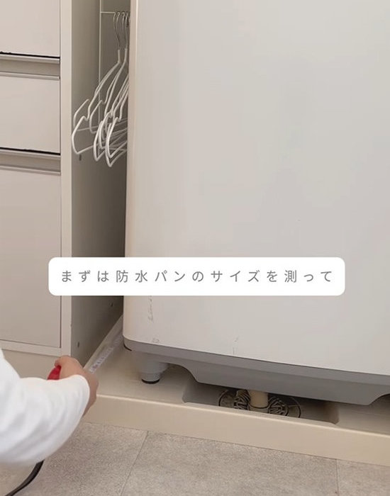 洗濯機下の防水パンのサイズを測る様子