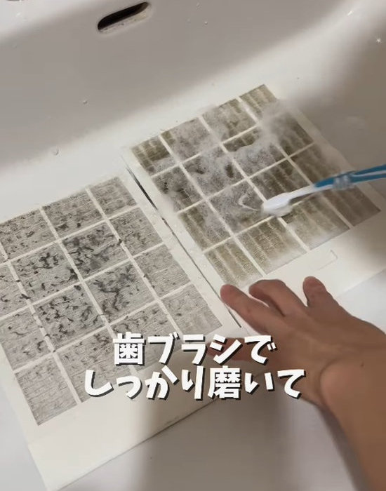 お風呂の換気扇のフィルターを歯ブラシで洗う様子