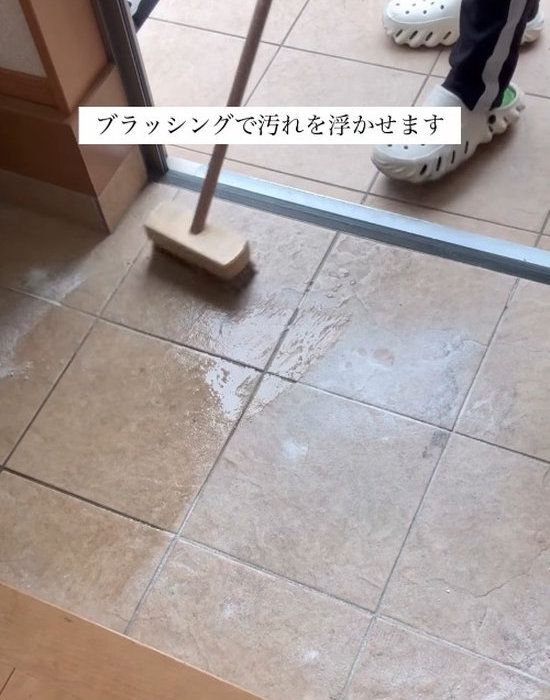 玄関タイルを重曹とブラシで掃除している様子