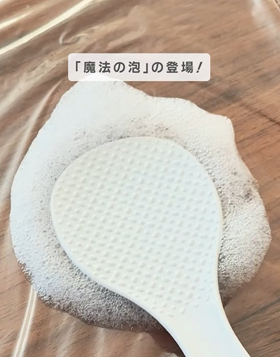 ラップに置いたしゃもじにキッチン泡ハイターを吹きかけた様子