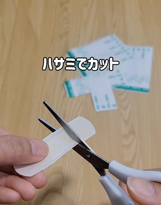 絆創膏をハサミでカットしている様子