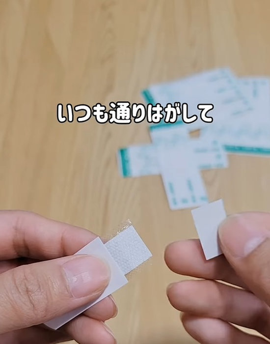 絆創膏のテープをはがしている様子