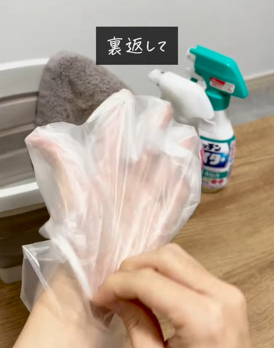 裏返すようにして外しながら、もう片方の手袋の上にかぶせている様子